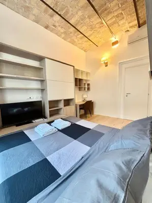 a bedroom with a bed and a desk in it at Ovidio Luxury in Rome