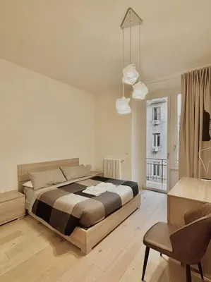 a bedroom with a large bed and a chair at Ovidio Luxury in Rome