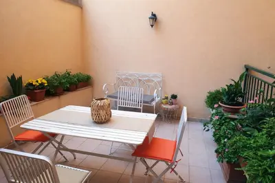 a patio with a table and chairs and potted plants at San Martino Home in Rome