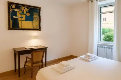 a room with a table and a chair and a painting at San Martino Home in Rome