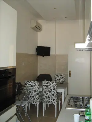 a kitchen with a table and chairs and a stove at Appia Nuova Holiday B&B in Rome