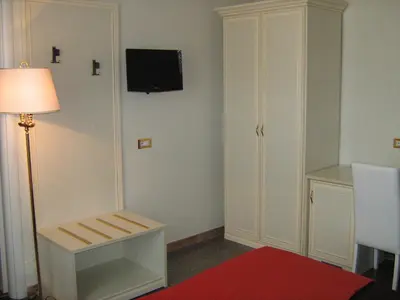 a room with a chair and a tv on the wall at Appia Nuova Holiday B&B in Rome