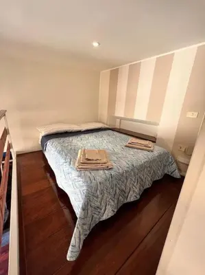 a small bedroom with a bed with two towels on it at Torre Argentina Apartment in Rome
