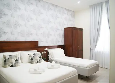 two beds in a hotel room with white walls at Monti 66 Hotel in Rome
