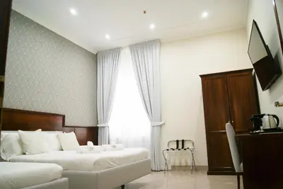 a hotel room with two beds and a television at Monti 66 Hotel in Rome
