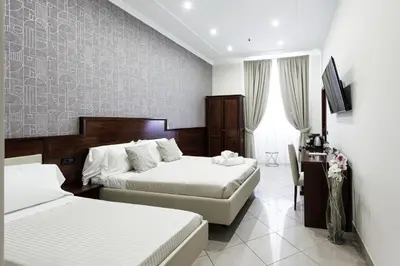 a hotel room with two beds and a desk at Monti 66 Hotel in Rome