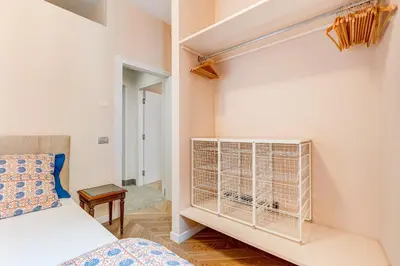 a bedroom with a bed and a white wall at BMGA l Luxury Home with Patio in Trastevere in Rome