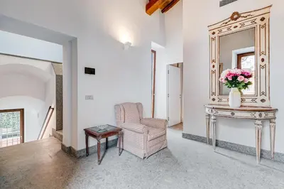 a living room with a chair and a mirror at BMGA l Luxury Home with Patio in Trastevere in Rome