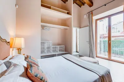 a bedroom with a large bed and a window at BMGA l Luxury Home with Patio in Trastevere in Rome