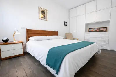 a bedroom with a large bed with a green blanket at 15 MIN FROM THE VATICAN Wi-fi and garden in Rome
