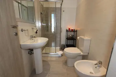 a bathroom with a sink and a toilet and a shower at Aria Rome Rooms in Rome