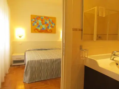 a bathroom with a bed and a sink and a sink at Buonarroti Guest House in Rome