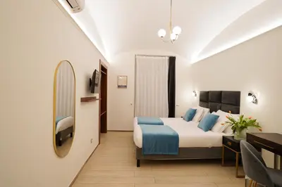 a hotel room with a bed and a desk at Charm&Bella GuestHouse in Rome