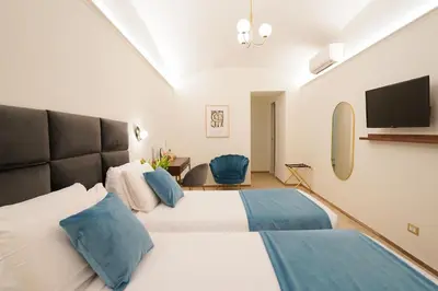 a bedroom with two beds and a flat screen tv at Charm&Bella GuestHouse in Rome