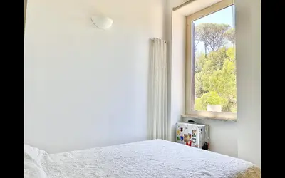 a bedroom with a bed and a window at Charming mini apartment near Vatican with parking in Rome