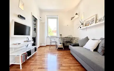 a living room with a couch and a tv at Charming mini apartment near Vatican with parking in Rome
