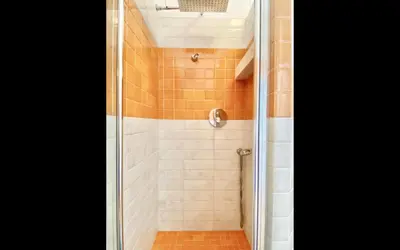 a shower with a glass door in a bathroom at Charming mini apartment near Vatican with parking in Rome