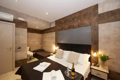a hotel room with a bed and a table with a bottle of wine at Blue Suite Vatican Guesthouse in Rome