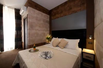 a hotel room with a bed with a bottle of champagne at Blue Suite Vatican Guesthouse in Rome