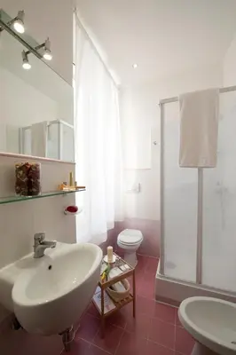 a white bathroom with a sink and a toilet at Blue Suite Vatican Guesthouse in Rome