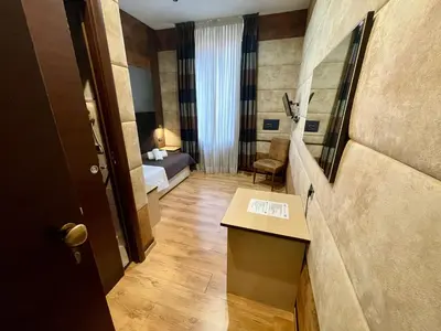 a small hotel room with a bed and a table at Blue Suite Vatican Guesthouse in Rome