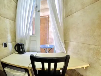 a table and a chair in a room with a window at Blue Suite Vatican Guesthouse in Rome