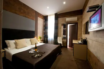 a hotel room with a bed and a television at Blue Suite Vatican Guesthouse in Rome