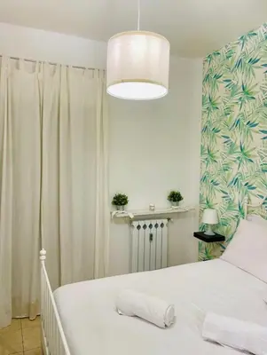 a bedroom with a large white bed with a chandelier at Inn Trastevere in Rome