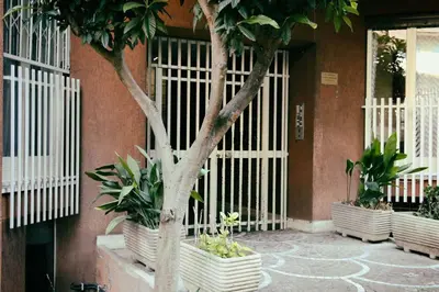 a building with white gates with trees and plants at Inn Trastevere in Rome