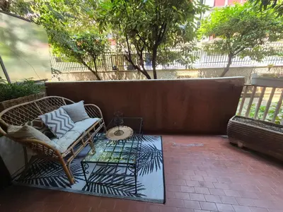 a wicker chair and a table on a patio at Inn Trastevere in Rome