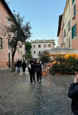 a group of people walking down a cobblestone street at Inn Trastevere in Rome