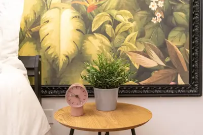a table with a clock and a potted plant on it at Rhome_Hub in Rome