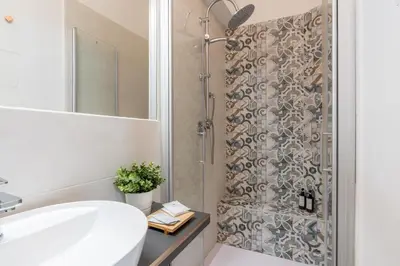 a bathroom with a shower with a white sink and a mirror at Rhome_Hub in Rome