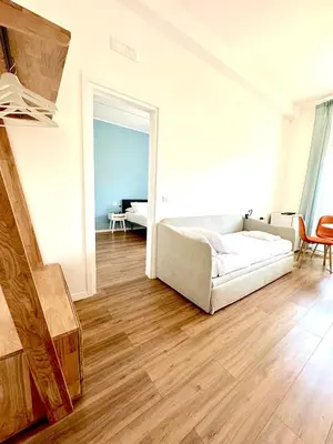 a bedroom with a bed with white sheets and a window at Lexie Suites in Rome