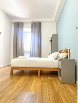 a bedroom with a bed and a wooden floor at Lexie Suites in Rome