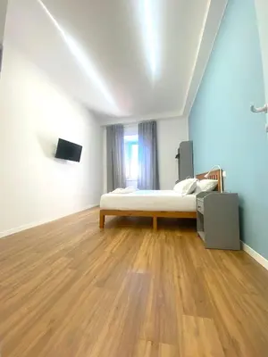 a room with two beds and a mirror at Lexie Suites in Rome