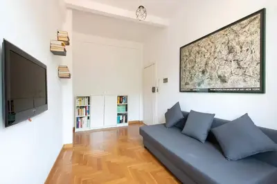 a living room with a blue couch and a flat screen tv at Casa Vittoria Stadio olimpico con panorama in Rome