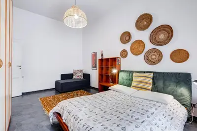 a bedroom with a bed and a couch and plates on the wall at Termini Sweet Home in Rome
