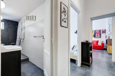a white bathroom with a sink and a bedroom at Termini Sweet Home in Rome