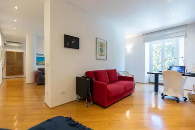 a living room with a red couch and a table at San Gioacchino View by Rental in Rome in Rome