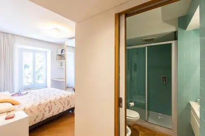 a bedroom with a bed and a glass shower at San Gioacchino View by Rental in Rome in Rome