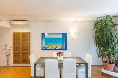 a dining room with a table and white chairs at San Gioacchino View by Rental in Rome in Rome