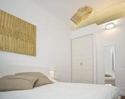 a white bedroom with a bed and a ceiling at Vatican Charme in Rome