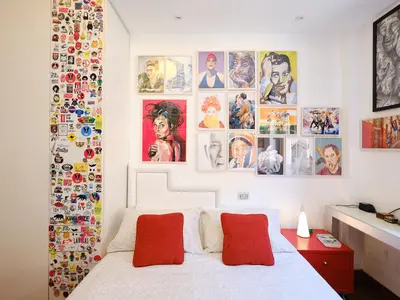 a bedroom with a bed and many pictures on the wall at Marisol's House, Colosseo in Rome