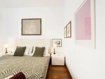 a white room with a bed and a table at Marisol's House, Colosseo in Rome