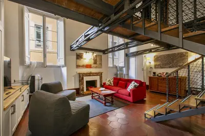 a living room with a red couch and a fireplace at Pantheon Palazzo Nari #9 in Rome