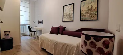 a bedroom with a bed and a couch and a table at A casa di Marisa in Rome