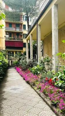 a walkway in front of a building with flowers at A casa di Marisa in Rome