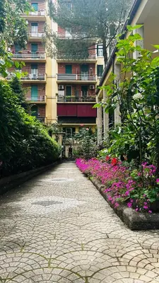a brick road in front of a building with flowers at A casa di Marisa in Rome