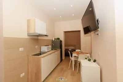 a kitchen and dining room with a table and a television at Domus Degli Dei in Rome